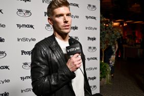 Kyle Cooke wearing a black leather jacket and holding a microphone